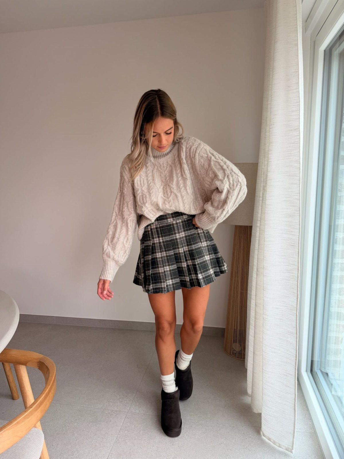 Pull torsadé beige et jupe plissée à carreaux
