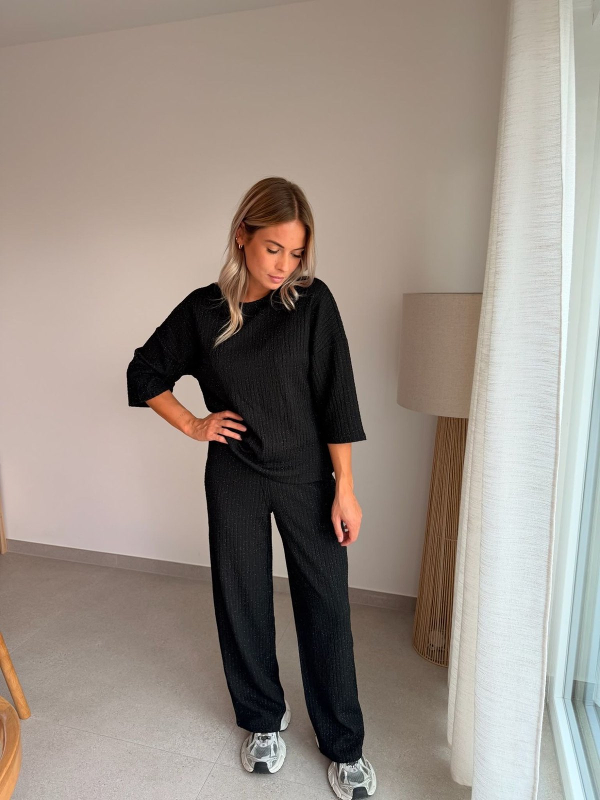 Ensemble top et pantalon Milla noir pailleté porté avec des baskets