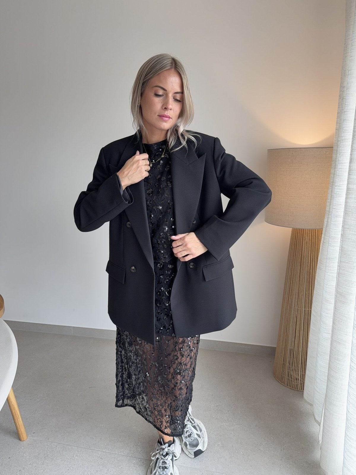 Top et jupe pailletés noirs sous un blazer noir